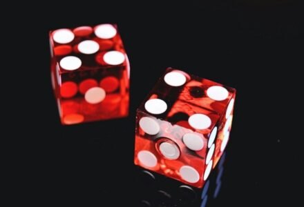 Close-up of two red dice on a shiny black background symbolizing luck and chance., tags: mobile apps - pexel