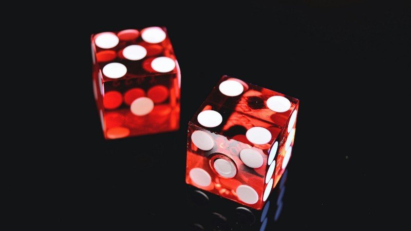 Close-up of two red dice on a shiny black background symbolizing luck and chance., tags: mobile apps - pexel