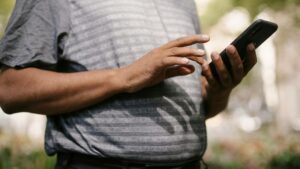 Crop anonymous male in casual clothes using smartphone on blurred background of street, tags: ontario gambling - pexel