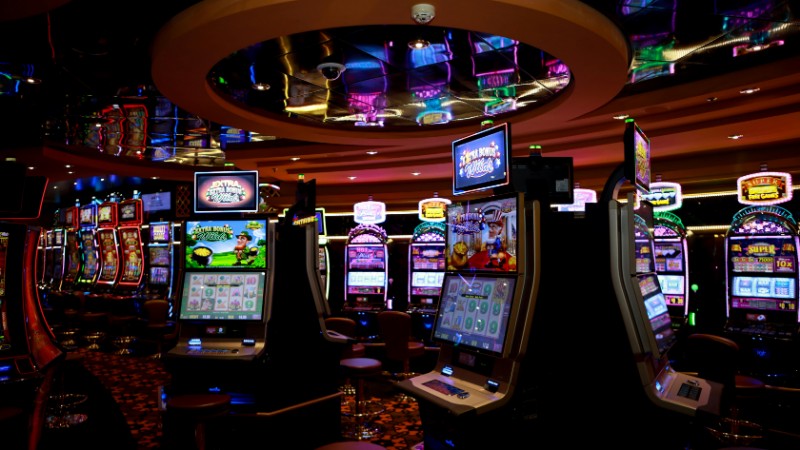 Vibrant casino floor with colorful slot machines and bright lights capturing a lively gaming atmosphere., tags: playtech - pexel