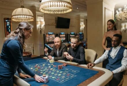 A diverse group of adults enjoying a night at the casino, playing roulette indoors., tags: canadian - pexel