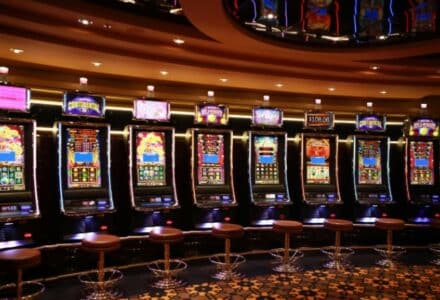 A row of luxury slot machines in a casino interior with plush stools, perfect for gaming enthusiasts., tags: money slots - pexel