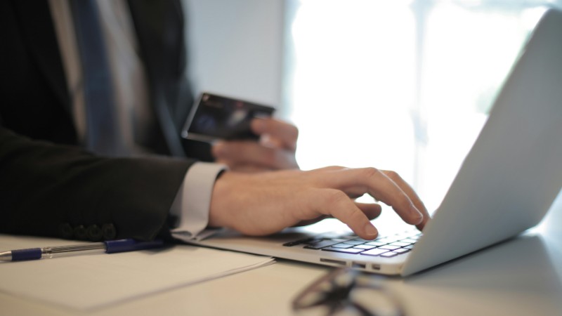 Man in suit using laptop and credit card for online transaction at work., tags: canadian - pexel