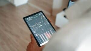 Close-up of person using a tablet displaying trading graphs indoors., tags: gambling - pexel